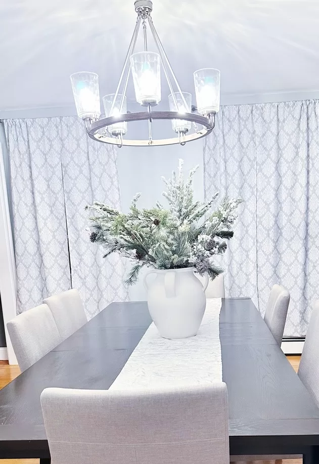 Dining room table decorated with a Christmas filled vase