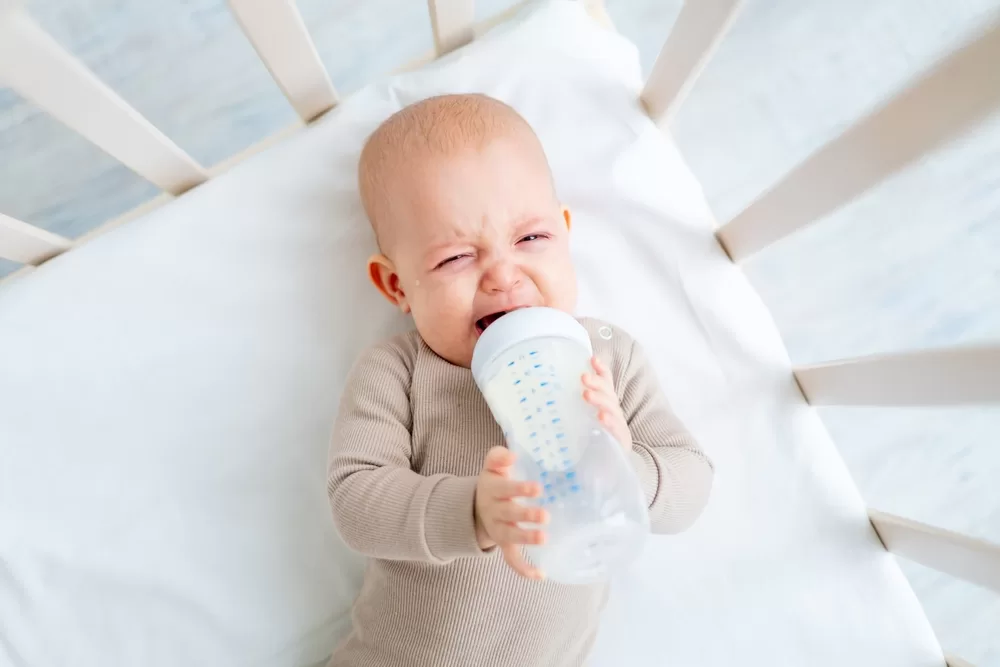 crying baby drinking bottle