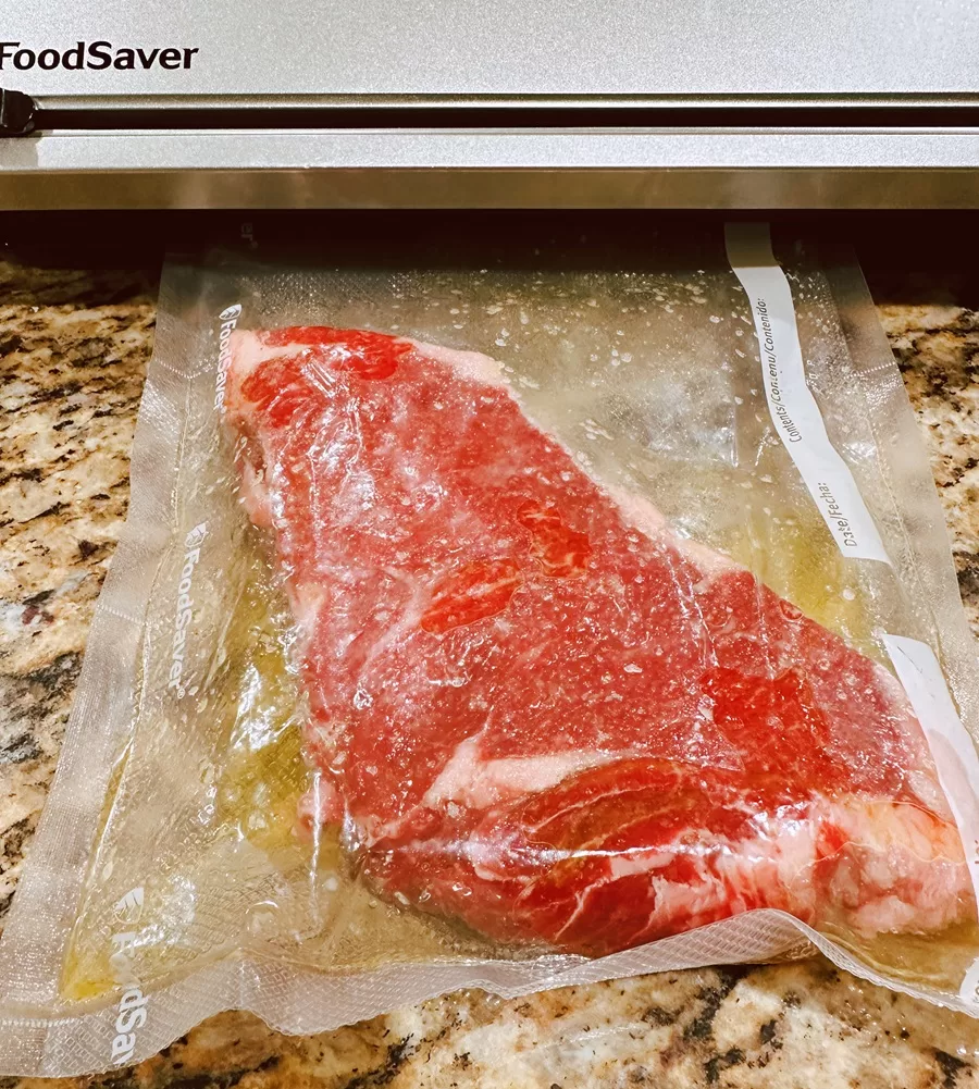 new york strip steak getting vacuum sealed