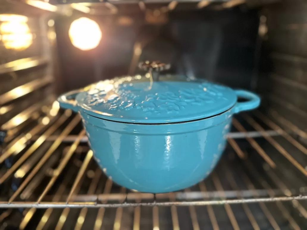 blue dutch oven roasting in oven