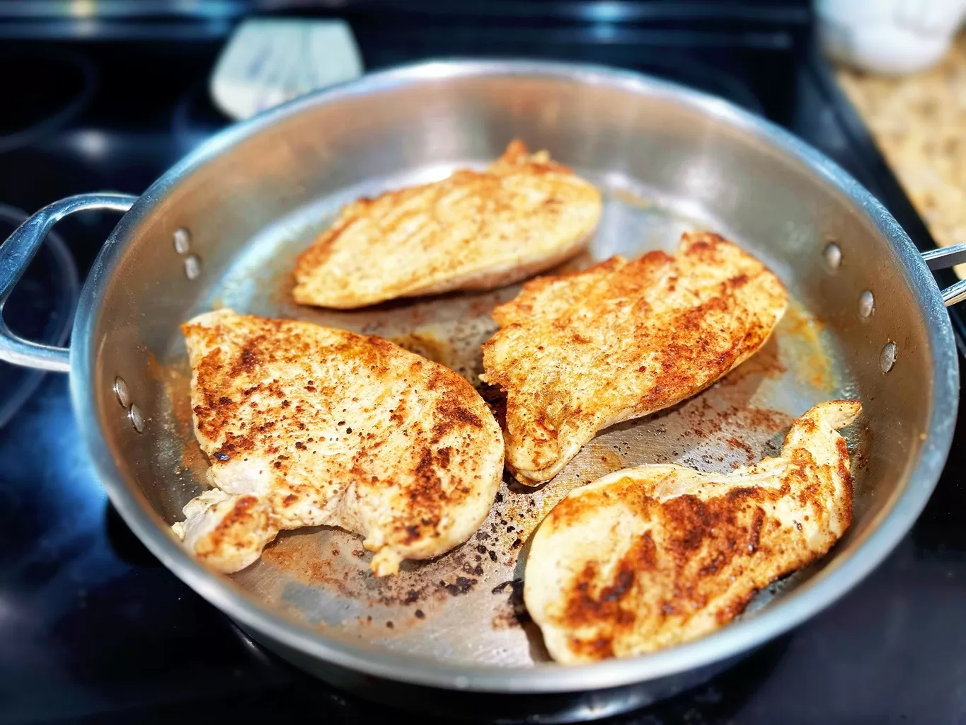 browned chicken breasts cooking in a pan