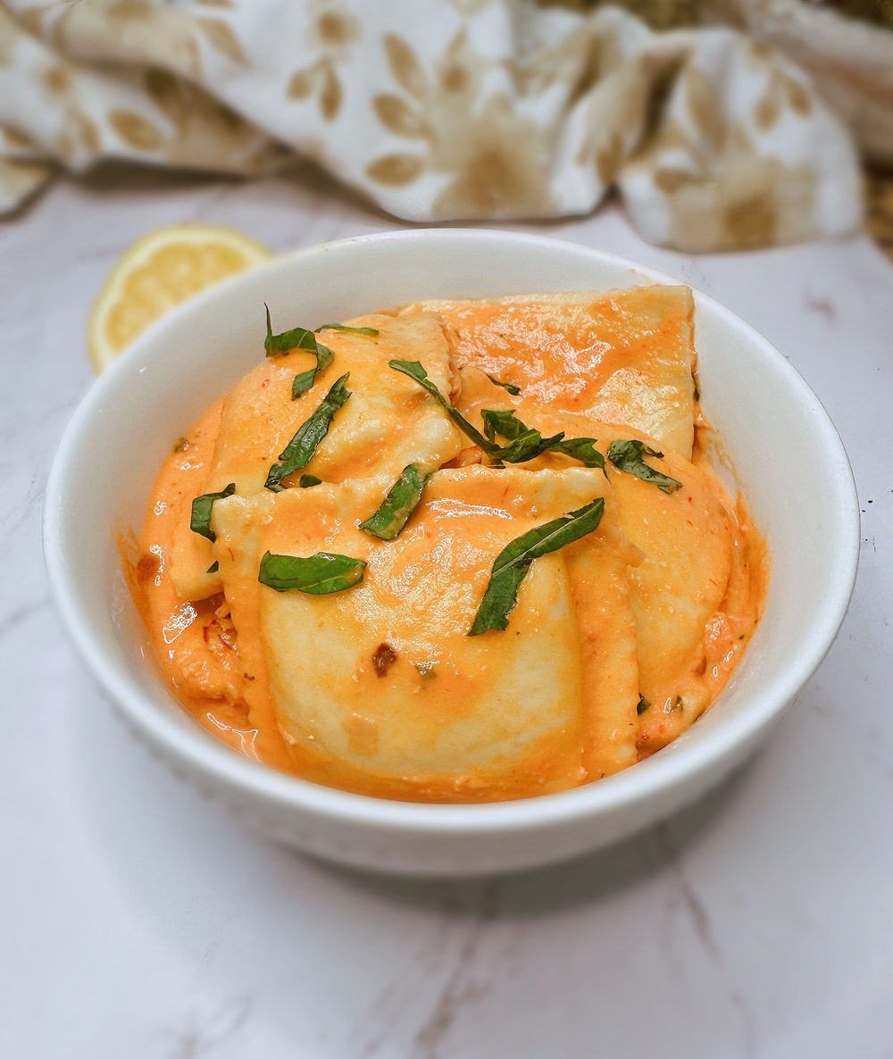 lobster ravioli with pink sauce in a white bowl