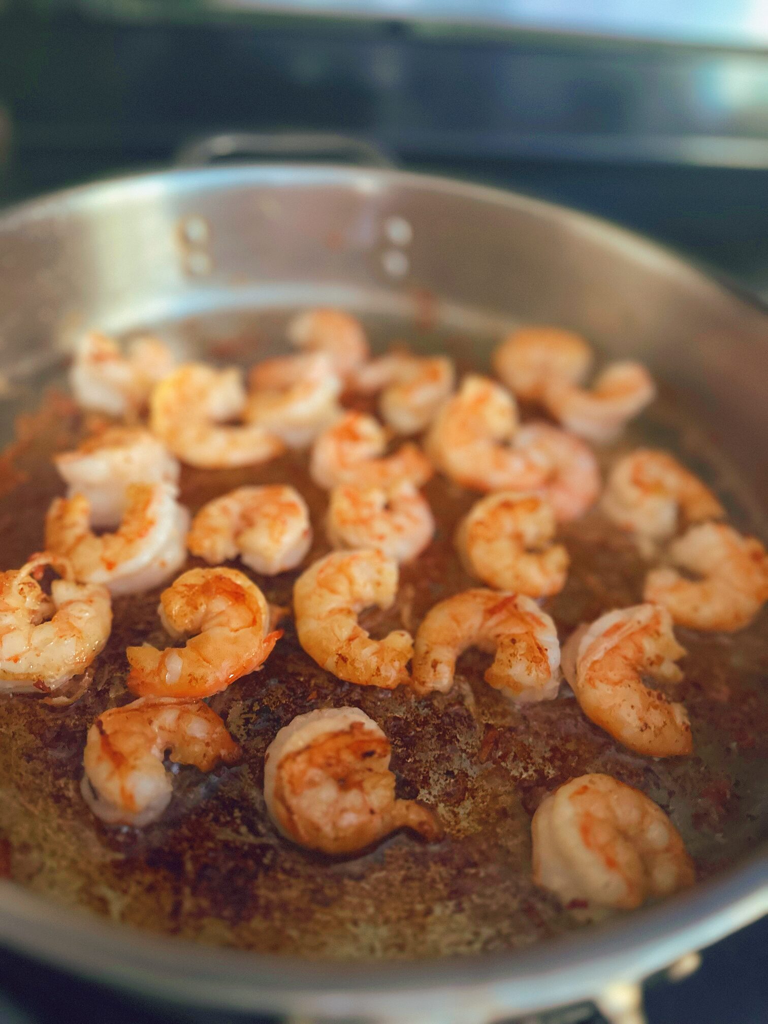 closeup of fresh shrimp searing in a frying pan