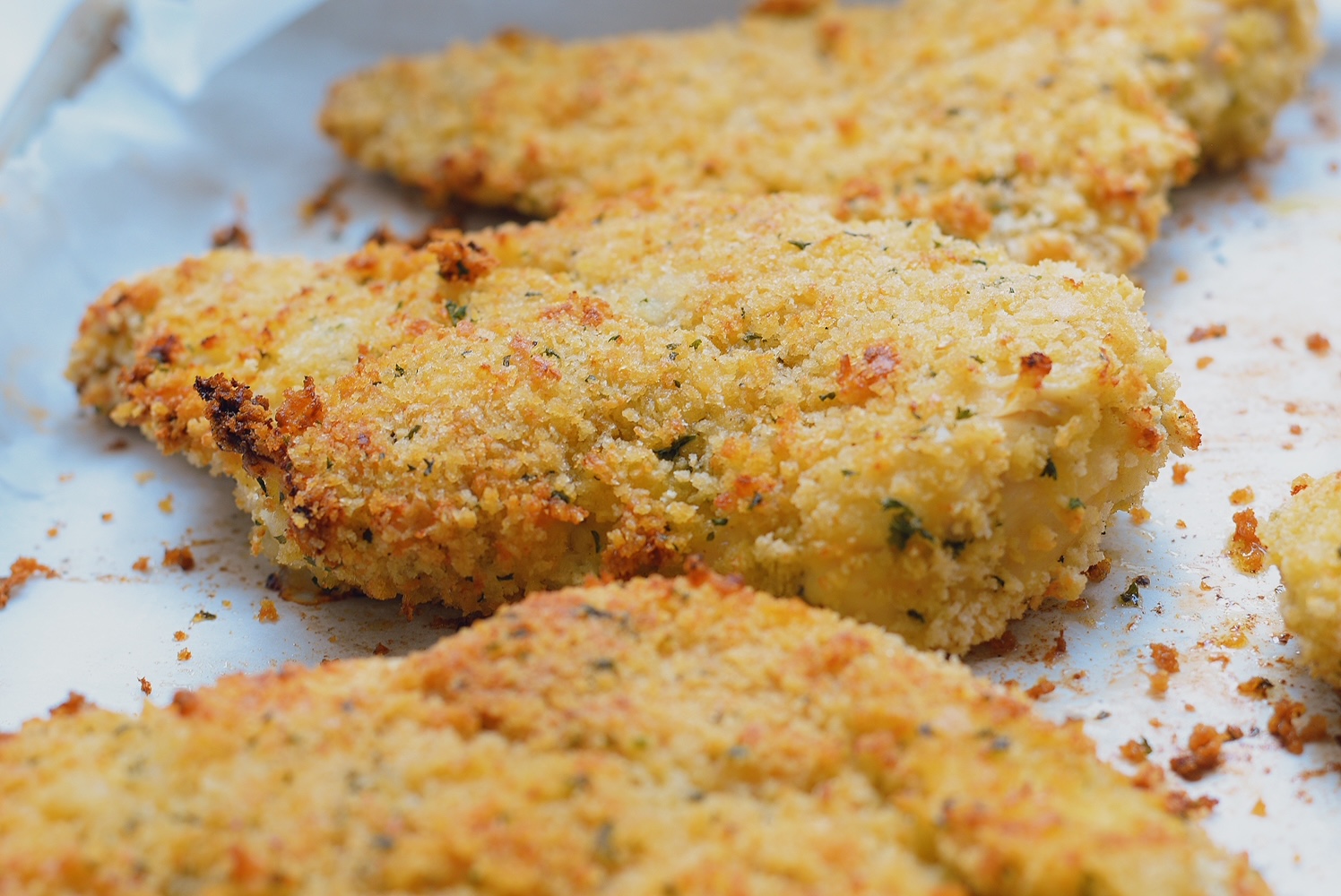 oven fried chicken on a baking sheet with parchment paper