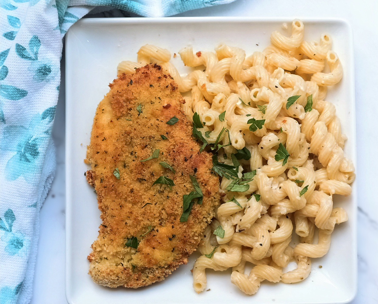 oven fried chicken with garlic parmesan sauce over cavatappi pasta