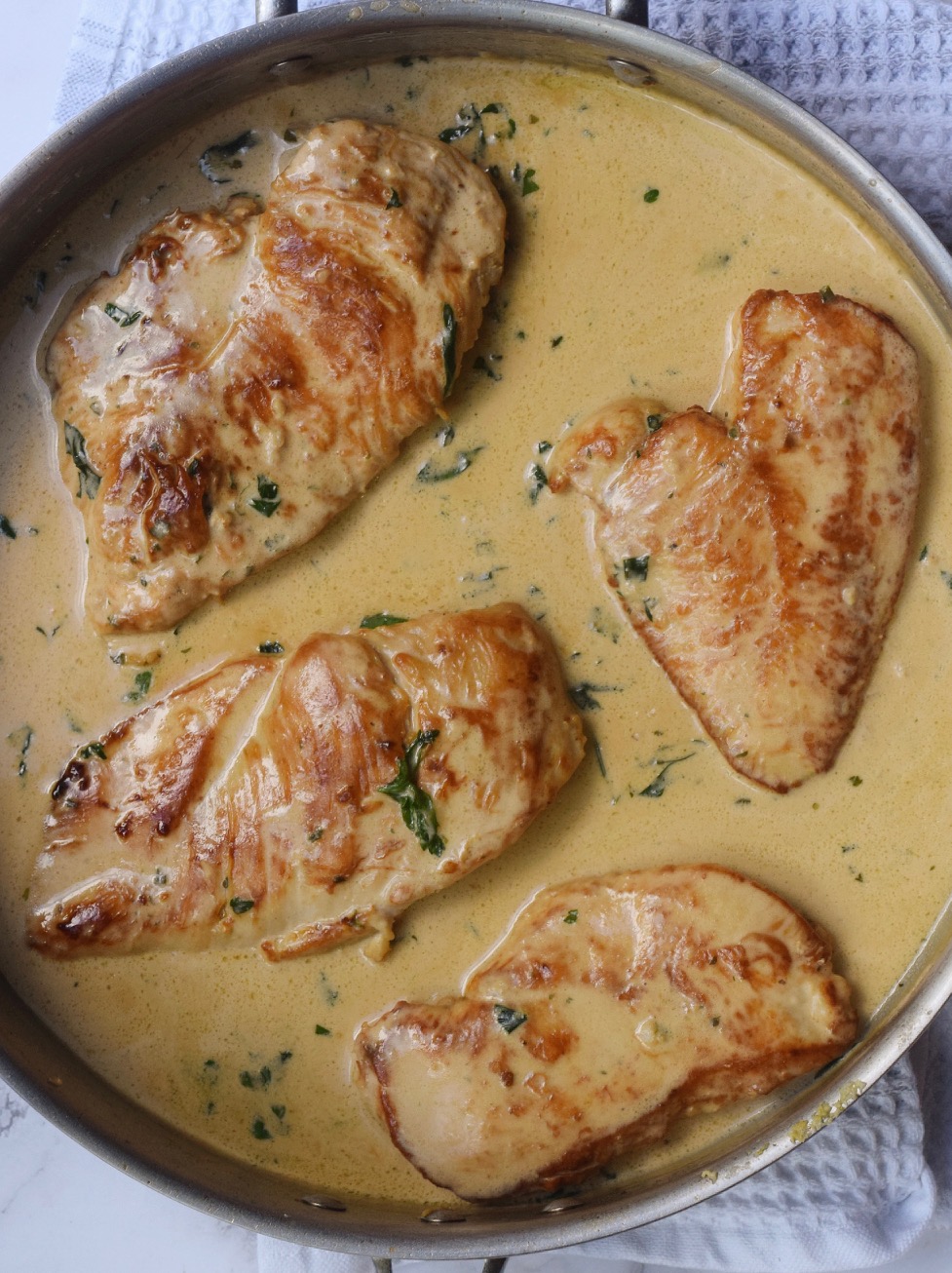 Garlic Herb Boursin Chicken simmering in sauce in a frying pan