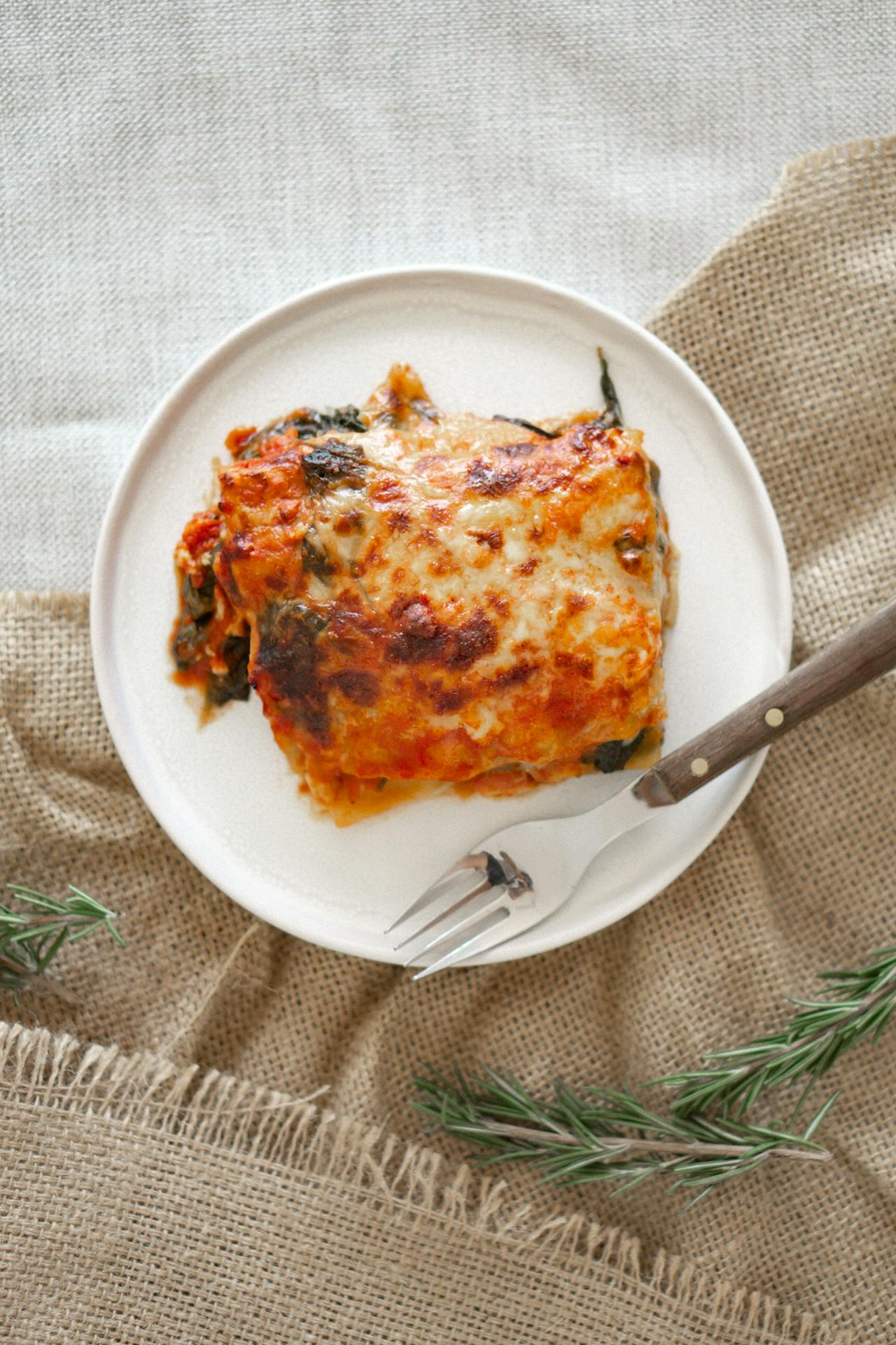 vegetarian lasagna on a white plate with a silver fork