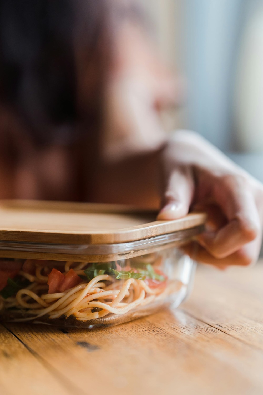 woman closing the lid to a freezer meal