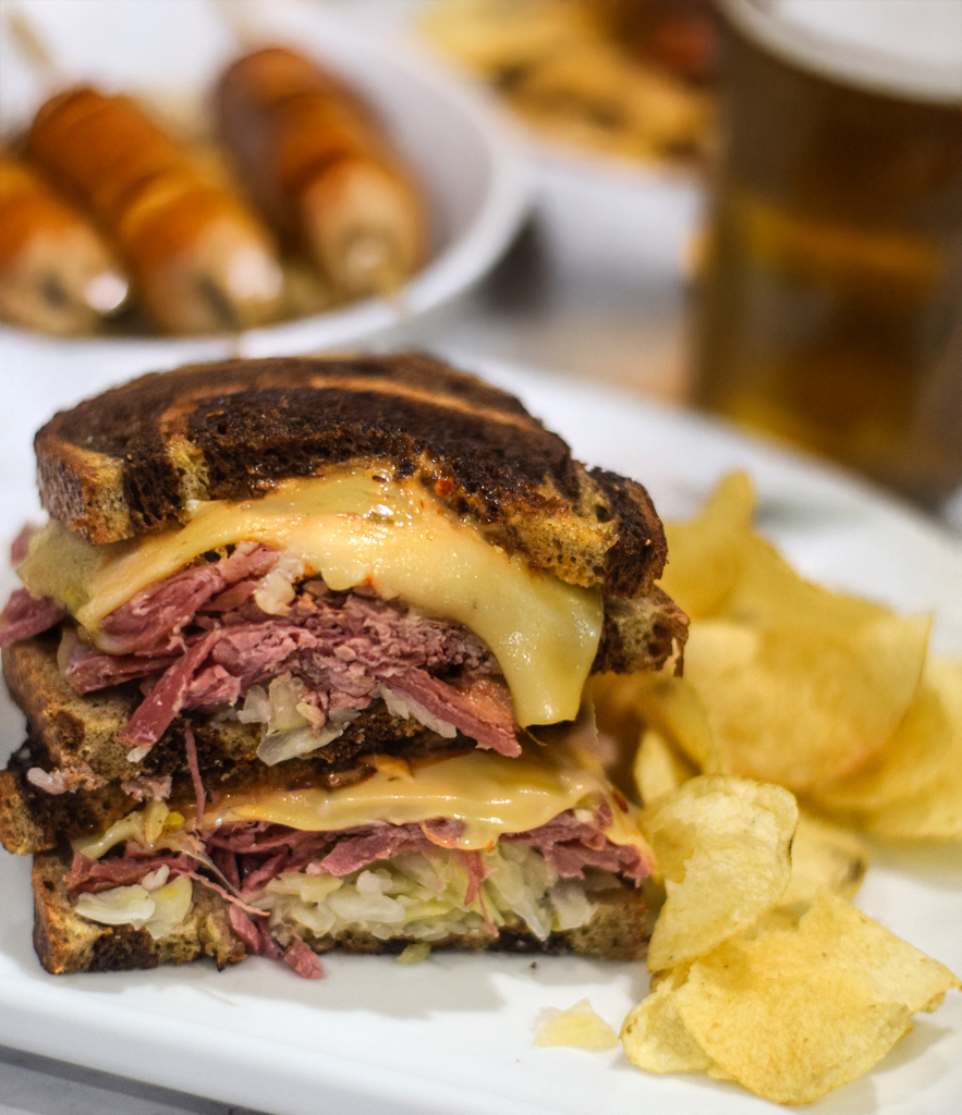 Reuben sandwich served on a plate with potato chips