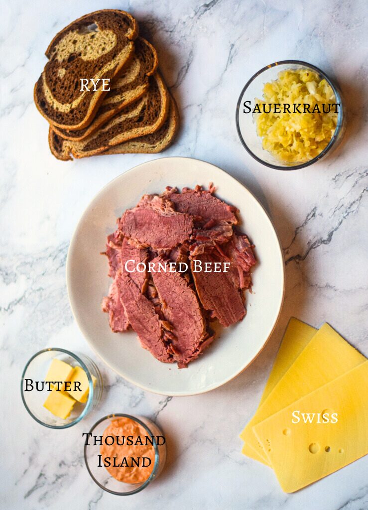 reuben sandwich ingredients laid out on white background