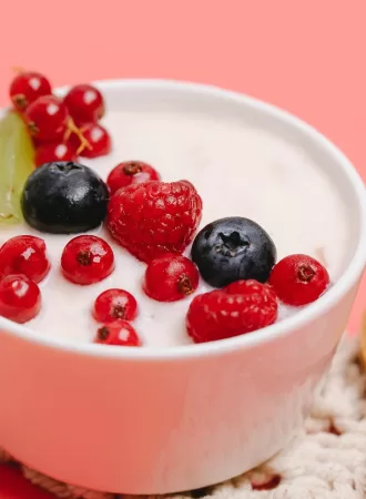 bowl of greek yogurt topped with raspberries and blueberries