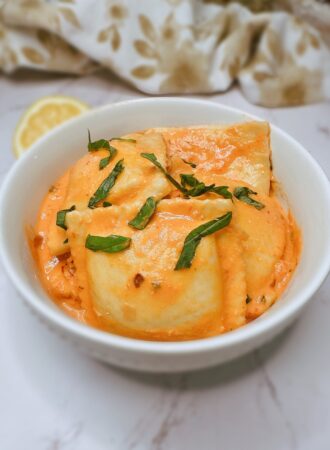 lobster ravioli with pink sauce in a white bowl