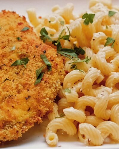 oven fried chicken with garlic parmesan sauce over cavatappi pasta