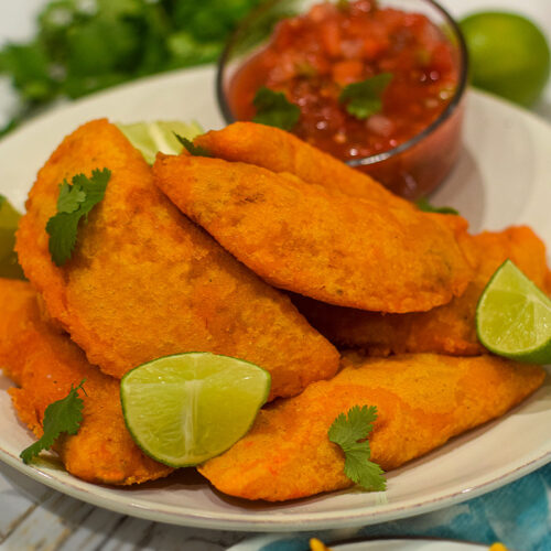 colombian empanadas served with salsa topped with cilantro and fresh lime