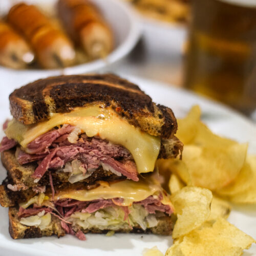 Reuben sandwich served on a plate with potato chips